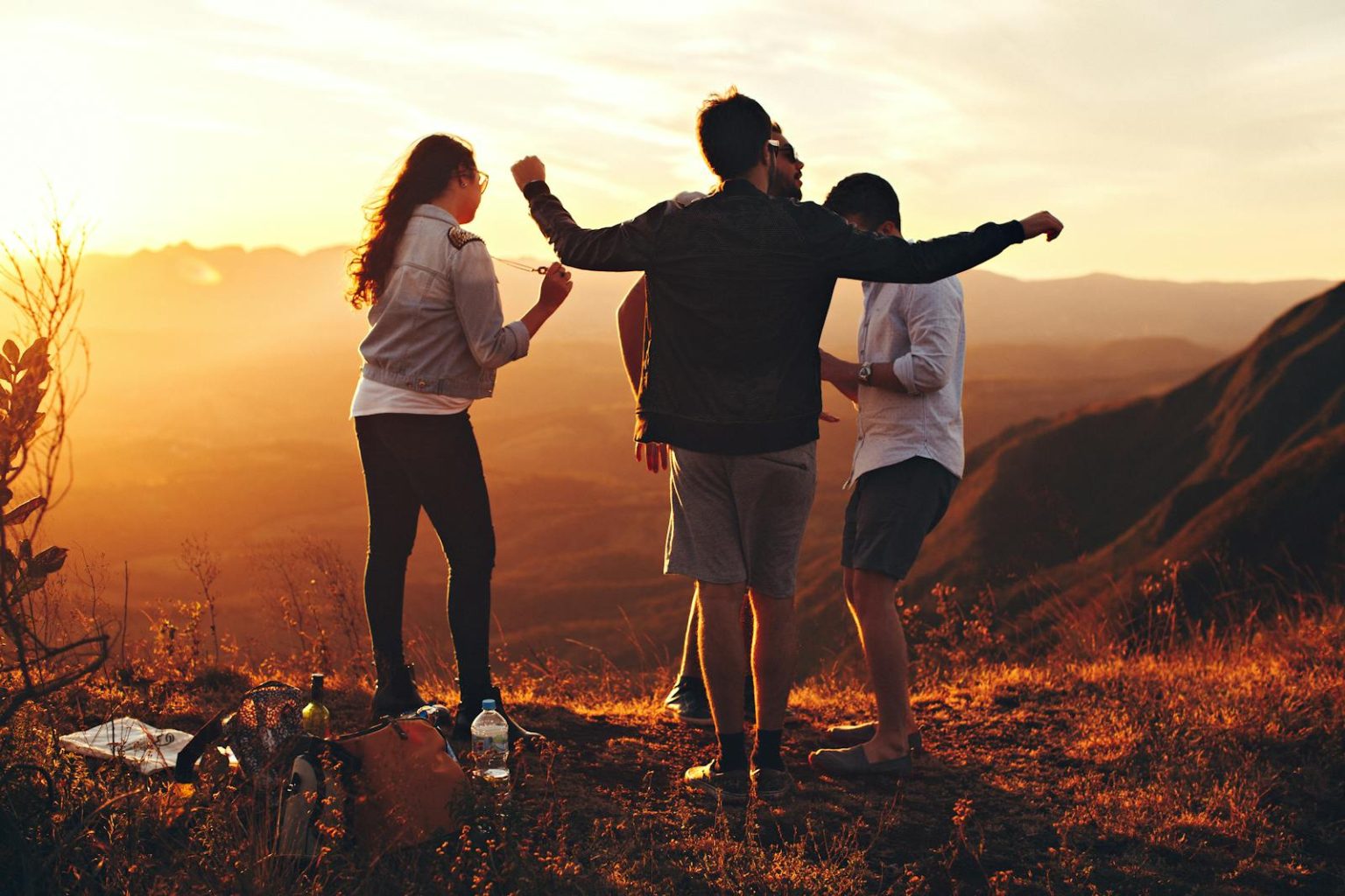 Joyful group of young adults enjoying a sunset view in a mountainous landscape in Brazil.