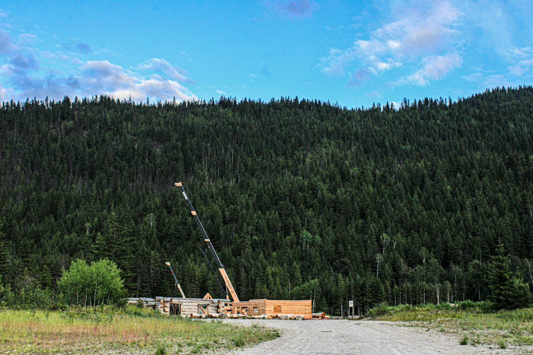 Crane and heavy construction equipment at a mountain project site, illustrating skilled trades and infrastructure careers in northern British Columbia