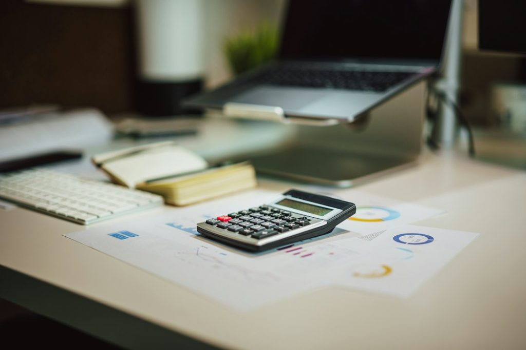 Calculator and laptop used to compare total compensation packages in Canada