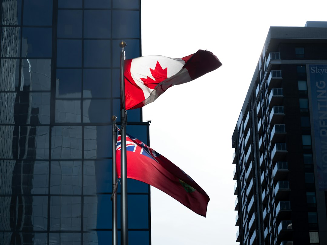 Canadian flags outside office buildings, representing pay transparency rules across Canada